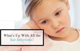 child holding ear words whats up with ear infections